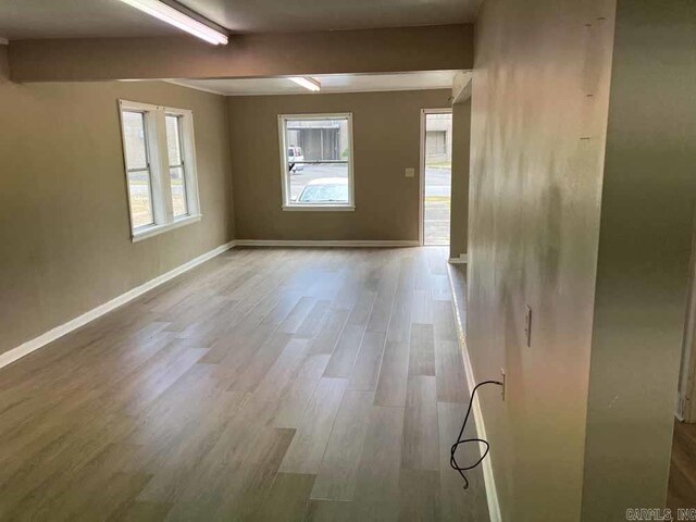 unfurnished room featuring beamed ceiling and wood-type flooring