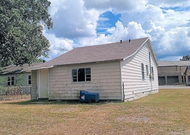 rear view of property featuring crawl space, a lawn, and fence