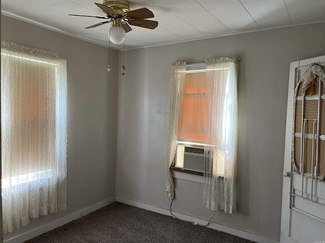 carpeted empty room featuring ceiling fan, baseboards, and cooling unit