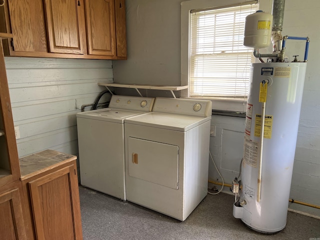 washroom with cabinet space, gas water heater, and independent washer and dryer