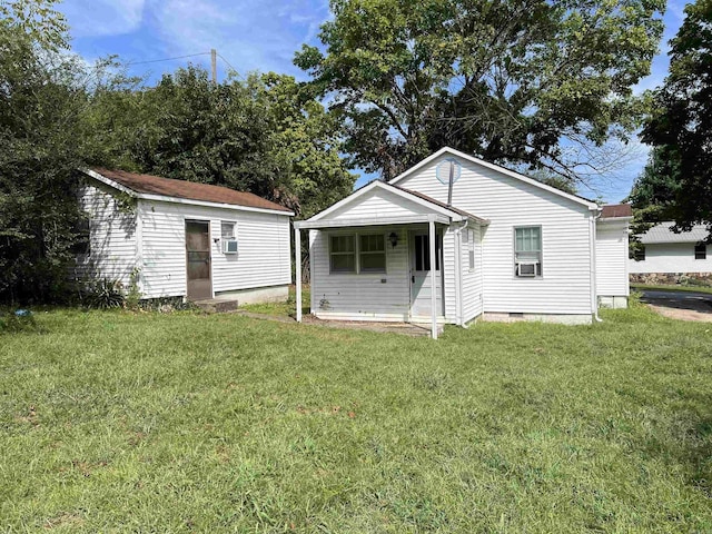 rear view of house featuring crawl space, an outbuilding, cooling unit, and a yard