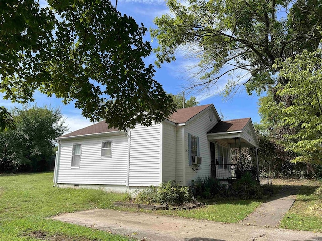 view of side of home with crawl space, a porch, and a yard