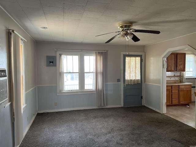 foyer entrance featuring cooling unit, wainscoting, and light carpet