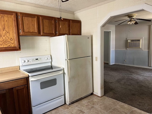 kitchen with light carpet, white appliances, arched walkways, a wall unit AC, and ceiling fan