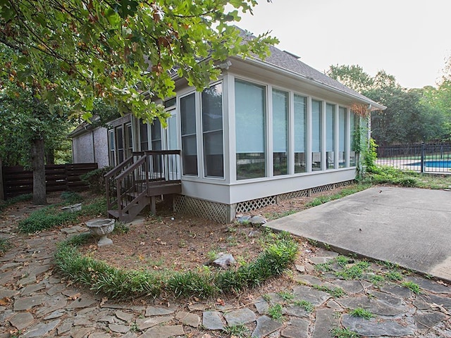 view of property exterior with a fenced in pool and a patio