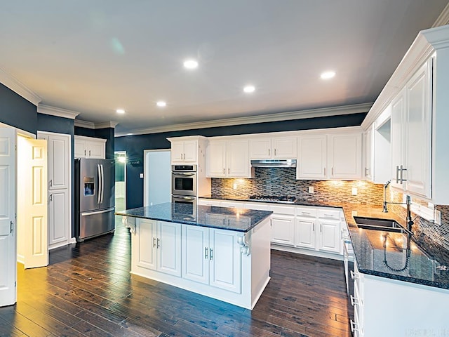 kitchen featuring crown molding, stainless steel appliances, a center island, sink, and white cabinets