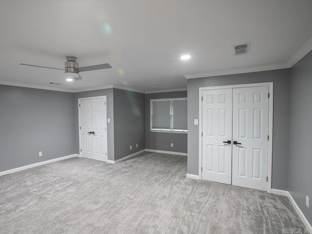 unfurnished bedroom with ceiling fan, light colored carpet, and crown molding