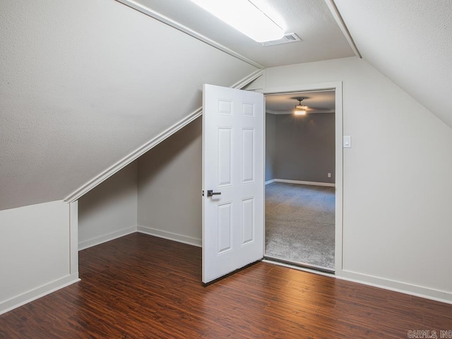 bonus room featuring vaulted ceiling, dark hardwood / wood-style flooring, and a textured ceiling