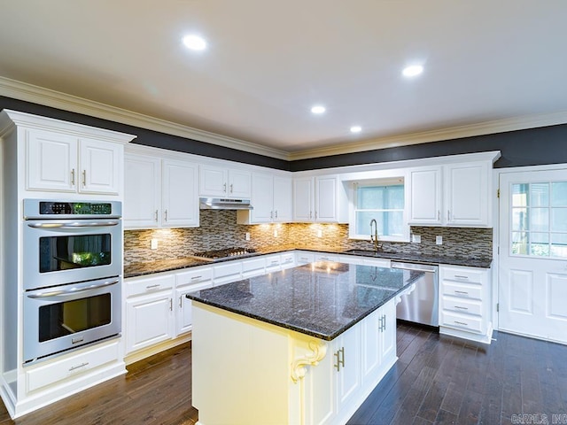 kitchen with stainless steel appliances, white cabinetry, and ornamental molding