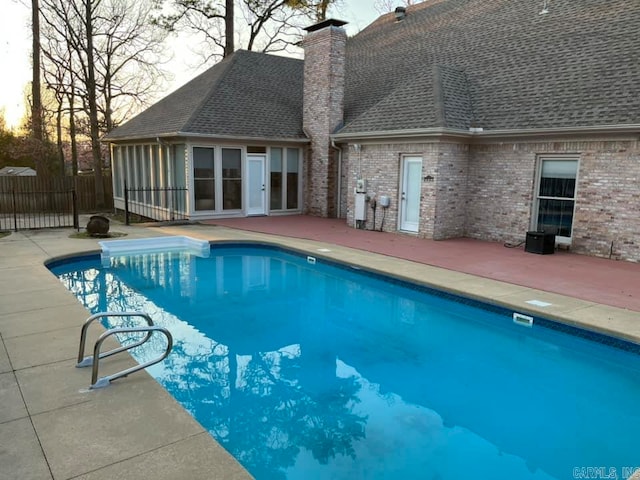 pool at dusk with a patio