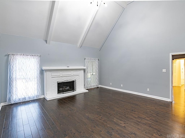 unfurnished living room with dark hardwood / wood-style flooring, high vaulted ceiling, beam ceiling, and a stone fireplace