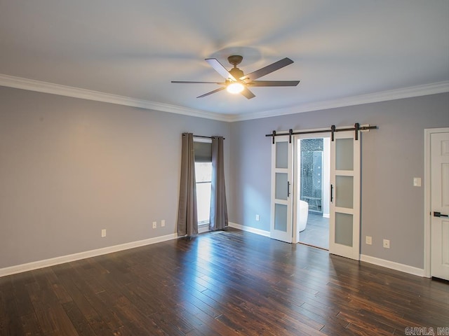 spare room with a barn door, ceiling fan, dark hardwood / wood-style floors, and ornamental molding