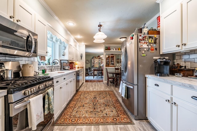 kitchen featuring white cabinets, stainless steel appliances, and light hardwood / wood-style floors