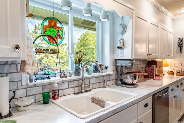 kitchen featuring white cabinets, backsplash, crown molding, sink, and stainless steel dishwasher