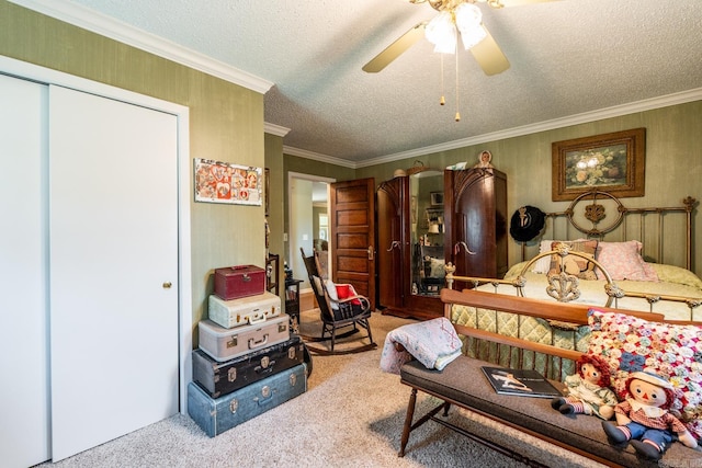 carpeted bedroom with a textured ceiling, ceiling fan, ornamental molding, and a closet