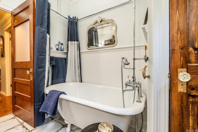 bathroom featuring ornamental molding, wood-type flooring, and a washtub