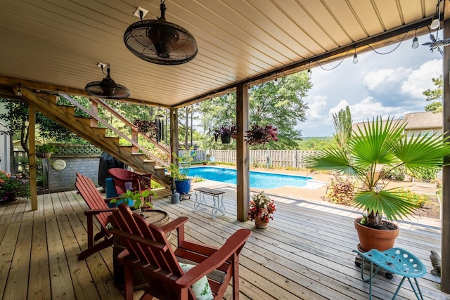 deck featuring ceiling fan and a fenced in pool