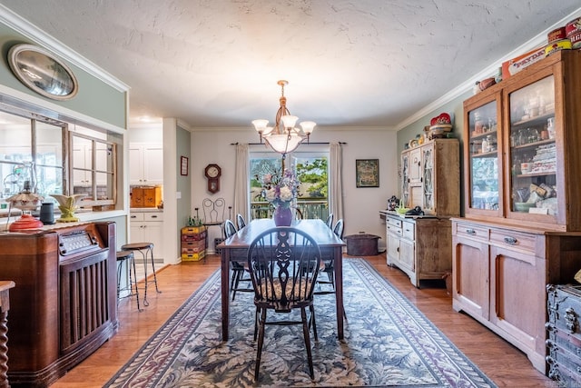 dining space with hardwood / wood-style floors, crown molding, a notable chandelier, and a textured ceiling