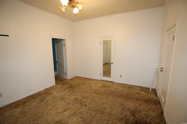 unfurnished room featuring a notable chandelier, ornamental molding, light carpet, and a textured ceiling