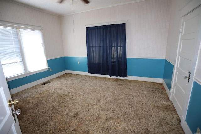 unfurnished room featuring ceiling fan, a wealth of natural light, and carpet