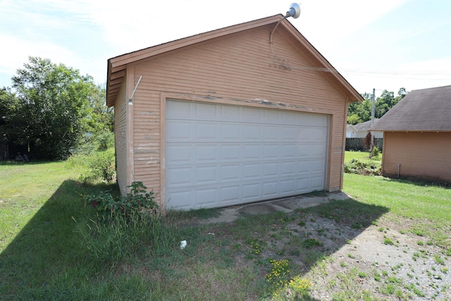 garage with a yard and wood walls