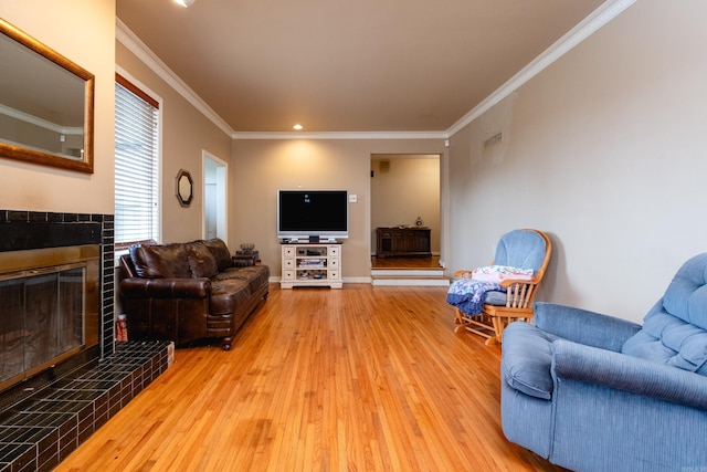 living room with hardwood / wood-style flooring, a fireplace, and crown molding