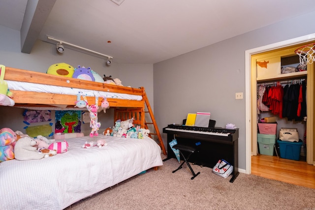 bedroom featuring a closet, hardwood / wood-style flooring, and beam ceiling