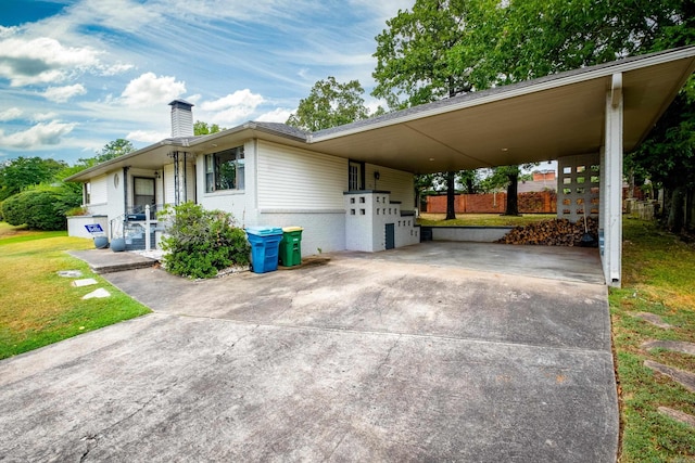 view of side of property featuring a yard and a carport