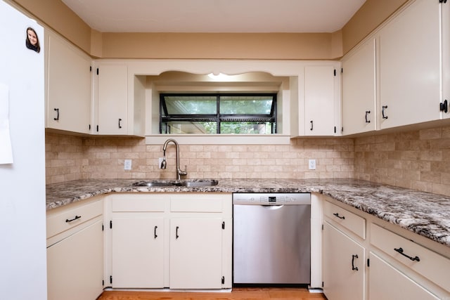 kitchen featuring white cabinetry, dishwasher, light stone counters, sink, and decorative backsplash