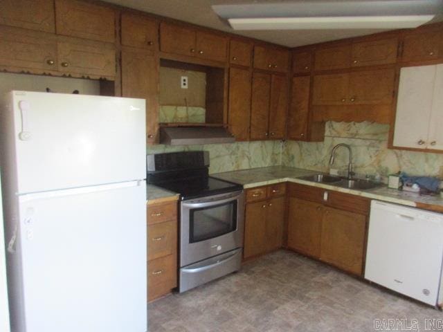 kitchen with sink, white appliances, and tasteful backsplash