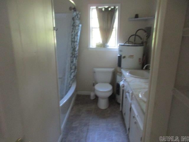 full bathroom with shower / bath combo with shower curtain, water heater, toilet, and vanity