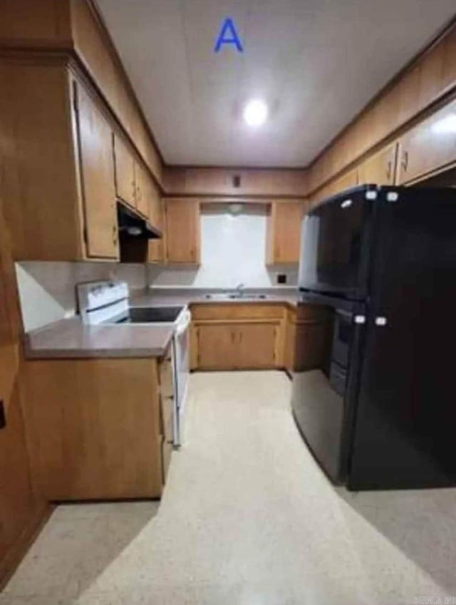 kitchen with sink, range hood, black fridge, and white electric stove