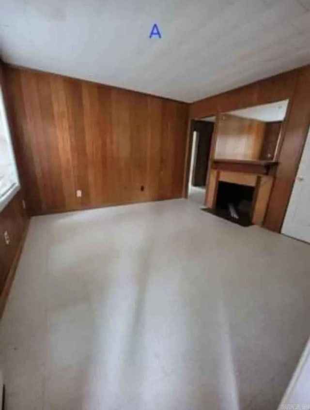 unfurnished living room featuring wood walls
