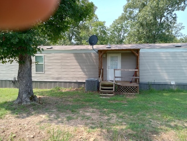 back of property with cooling unit and a lawn