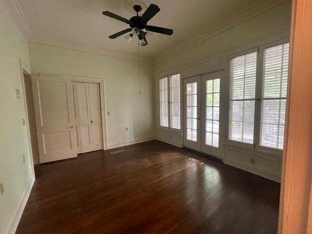 empty room with baseboards, dark wood-style flooring, ceiling fan, ornamental molding, and french doors