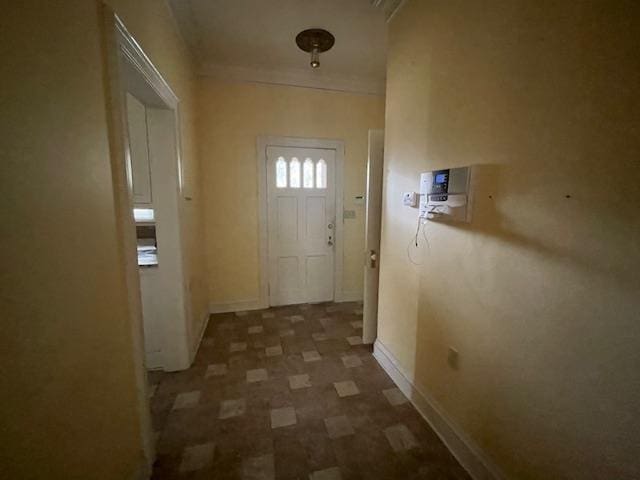 entryway with crown molding and baseboards