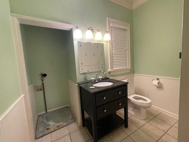 bathroom with vanity, tile patterned floors, toilet, and wainscoting