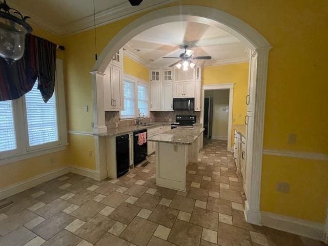 kitchen with baseboards, decorative backsplash, white cabinets, black appliances, and a sink