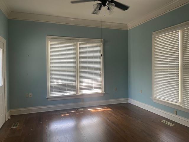 unfurnished room featuring a ceiling fan, visible vents, wood finished floors, baseboards, and ornamental molding