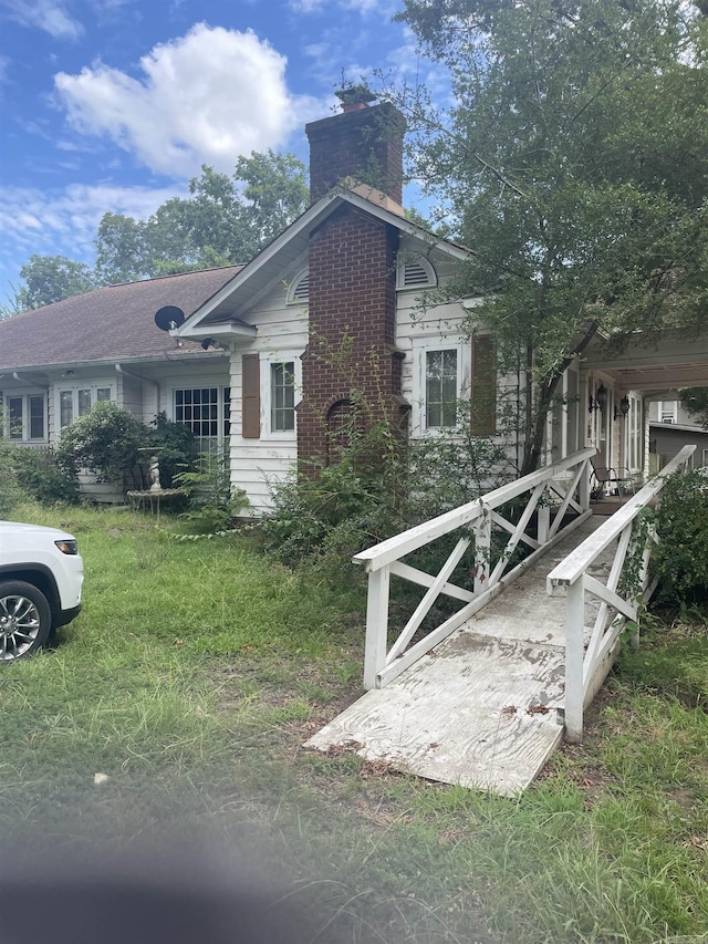 view of property exterior featuring a yard and a chimney