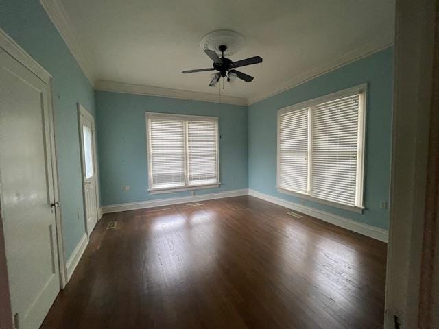 empty room with baseboards, dark wood finished floors, and ornamental molding