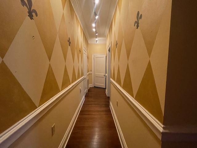 corridor featuring dark wood-style flooring, rail lighting, and ornamental molding