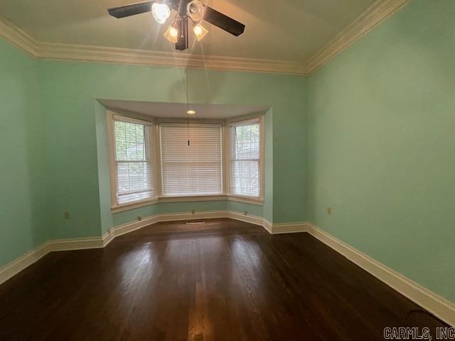 unfurnished room with ceiling fan, crown molding, baseboards, and wood finished floors