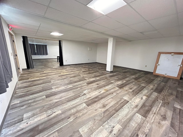 basement featuring a drop ceiling and wood-type flooring