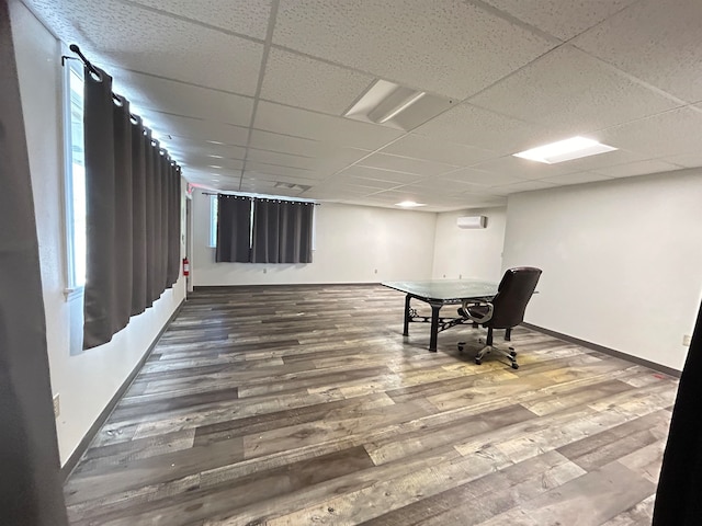 living area featuring a drop ceiling and hardwood / wood-style floors