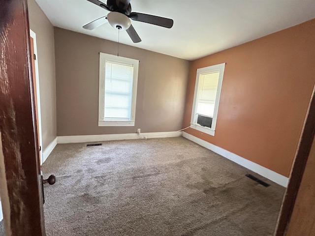 carpeted spare room featuring ceiling fan