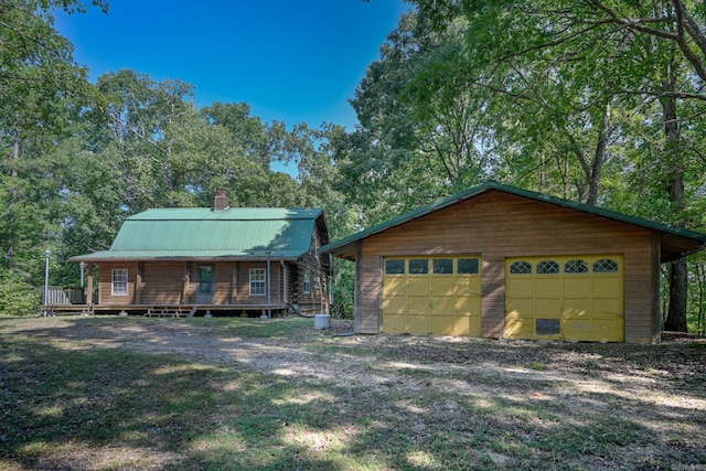 log-style house featuring an outdoor structure and a garage