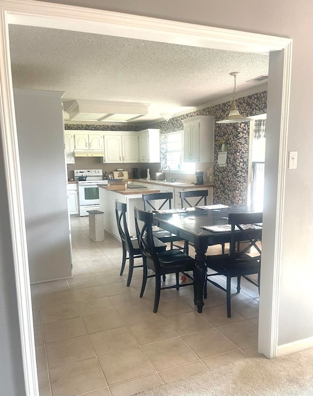 tiled dining room featuring a textured ceiling and sink