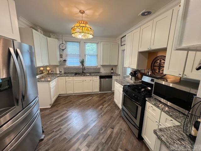 kitchen with appliances with stainless steel finishes, a sink, visible vents, and white cabinetry