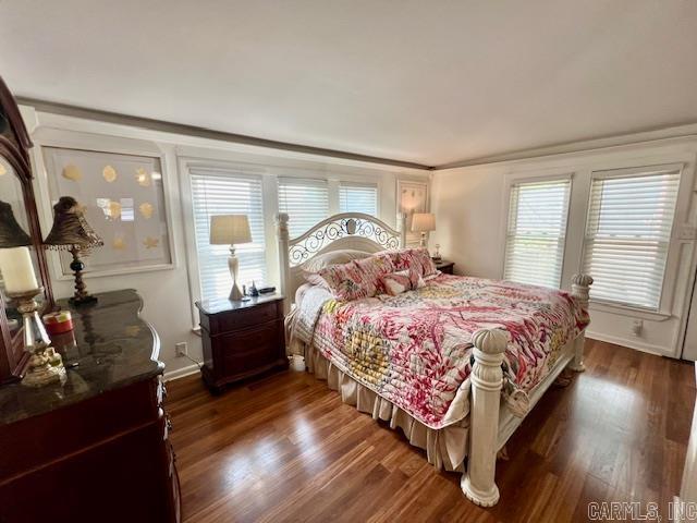 bedroom featuring dark wood finished floors and baseboards